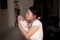 Lifestyle shot on young and happy Asian Chinese woman holding tenderly her adorable newborn baby girl in her arms in mother and