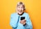 Lifestyle, tehnology and people concept: old granny looks at her smart phone and is surprised