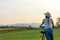 Lifestyle woman with bicycling at the garden meadow in sunset near mountain background.