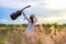 Lifestyle women white dress holding a guitar on a cloudy sunset or sunrise sky in the meadow flower, relax and happy day on summer