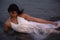 Lifestyle of young Indian woman enjoying her vacation on beach during sun set and wearing white one-piece gown and long flowy saro