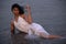 Lifestyle of young Indian woman enjoying her vacation on beach during sun set and wearing white one-piece gown and long flowy saro