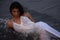 Lifestyle of young Indian woman enjoying her vacation on beach during sun set and wearing white one-piece gown and long flowy saro