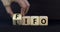 LIFO or FIFO last in first out symbol. Changes concept words LIFO to FIFO on wooden blocks. Beautiful grey table grey background.