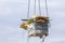 Lift basket with heap of garbage against blue sky