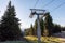 Lift with cable passes between spruce forest on peak against backdrop of mountain ranges of Rhodope Mountains