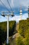 Lift with cable passes between spruce forest on peak against backdrop of mountain ranges of Rhodope Mountains