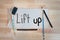 Lift up message painted in black paint with paintbrushes and art coloring pencils