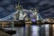 The lifted Tower Bridge in London, UK, by night