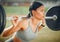 Lifting her spirits. Cropped shot of an attractive young female athlete exercising with weights outdoors.