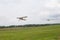 Light aircraft towing glider over airfield. General plan.