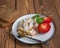 Light appetizer of chicken ham and tomato. Dining fork on a plate standing