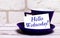 On a light background, a blue cup with a saucer and the inscription HELLO WEDNESDAY