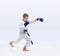 On a light background karateka with blue overlays on hands is beating punch