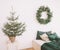 Light bedroom with a Christmas tree. Scandinavian style Christmas home interior, relaxing place. Real photo