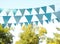 Light blue bunting flags in park. Party decor