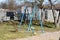 Light blue dilapidated homemade outdoor public playground equipment metal swing in family house backyard