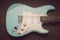 Light blue electric guitar in a purple texture background