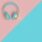 Light blue and gold audio headphones on a flat lay two-color background