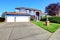 Light blue house exterior with brick trim and tile roof