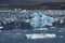 Light blue icebergs on JÃ¶kulsÃ¡rlÃ³n glacier lagoon with darker shaded water, Iceland