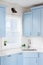 Light blue kitchen with a white countertop and subway tile backsplash.