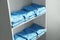 Light blue medical uniforms on white rack indoors