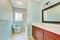 Light blue remodeled bathroom with wooden vanity cabinet.