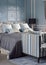 Light blue romantic style bedroom with reading lamp and sofa
