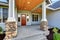 Light blue siding house . Porch with stone base columns.