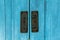 Light blue wooden door with steel gongs as a lock to prevent thieves and burglars from coming in. Contemporary vintage wooden