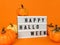 Light box with Happy Halloween phrase with pumpkins decoration on an orange background.