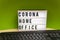 Light box with the inscription Corona Home Office stands on a desk and in front of it is a keyboard