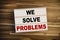 Light box or lightbox with message We Solve Problems on a wooden table background