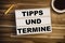 Light box or lightbox on a wooden tablet with the german words for tip and dates upcoming events - Tipps und Termine
