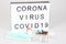 Light box with text coronavirus with drug capsule liquid and protective mask