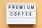 Light box with word premium coffee on wood background