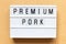 Light box with word premium pork on wood background