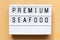 Light box with word premium seafood on wood background