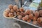 Light brown baobab tree fruits displayed at street market, heap placed on simple wooden cart, closeup detail