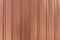 Light brown metallic striped surface. Gold background of metalline wall siding, cladding. Striated orange fence with shine, glitte