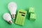 Light bulb, Green calculator, question mark on green background. Concept of competition for Green Energy market