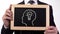 Light bulb head drawn on blackboard in businessman hands, creative business idea