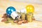 Light bulb with light from the lamp on stacked coins on a wooden table background - energy saving idea , power saving and the