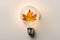 Light bulb made from maple and autumn leaves. renewable energy and sustainable living concept