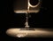 Light from bulb of modern sewing machine in darkness