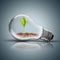 Light Bulb with soil and green plant sprout inside and butterfly