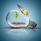 Light Bulb with soil and green plant sprout inside and butterfly