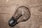 Light bulb on a wooden background. old glass lamp lies on the table