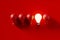 Light bulbs in a row with one glowing light bulb amongst the unlit red bulbs